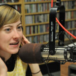 Radio presenter speaking into a studio microphone during a live broadcast